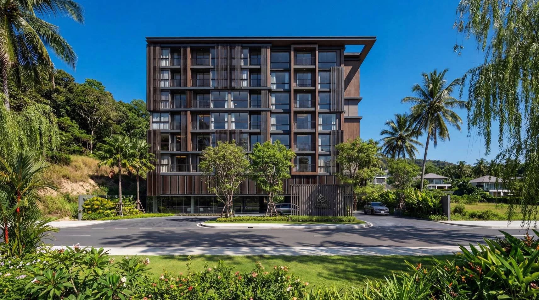 Building A, the 8-storey hotel, with its drop-off and lawn, green hill behind