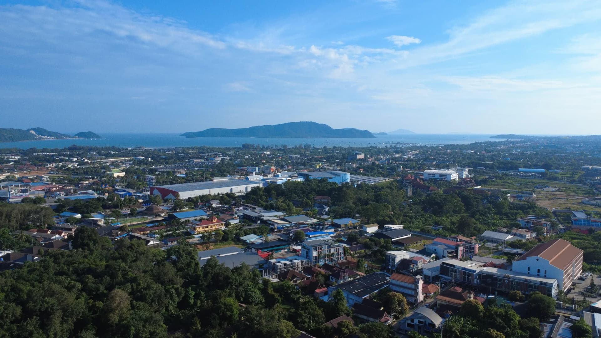 Drohnenfoto aus etwa 60 m Höhe: Chalong, die Chalong Bay und die Inseln unter blauem Himmel